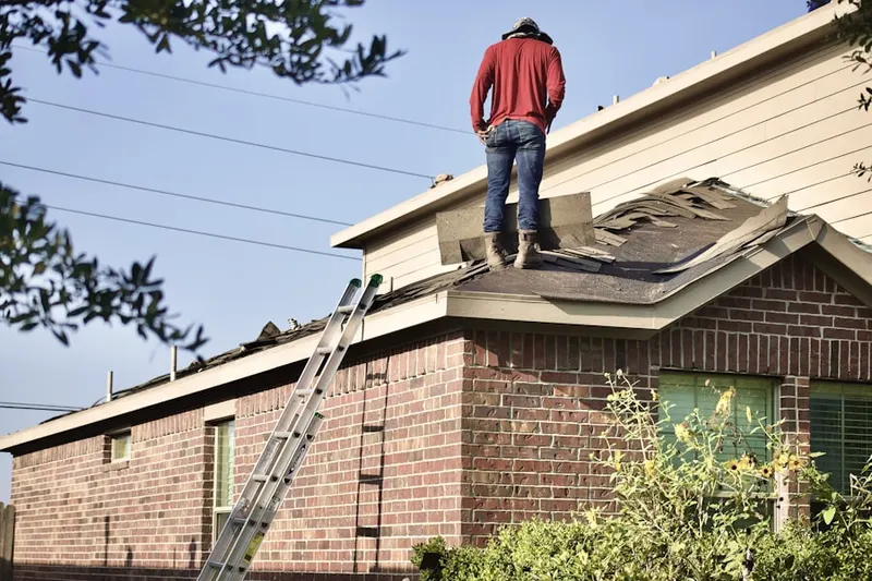 Professional roofer working on a residential roof in Winfrey